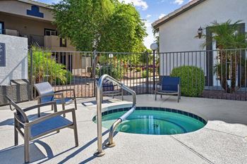 A small pool with a metal railing and a bench.